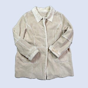 May include: Beige coat with a faux fur collar and trim. The coat has a button-up front, two front pockets, and decorative stitching. The sleeves have faux fur cuffs. A warm and stylish outerwear garment.