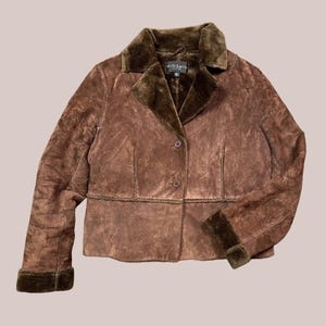 May include: Brown suede jacket with a faux fur collar and cuffs. The jacket has a button-up front and a tailored fit. The brand name "Willis Smith" is visible on a tag near the collar. A classic outerwear piece.
