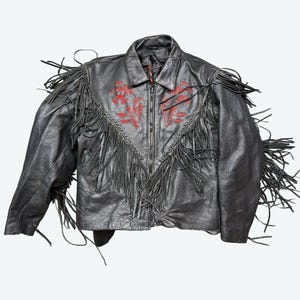 May include: Black leather jacket with red floral embroidery and long fringe detailing. The jacket features a zip-up front and a classic collar. The fringe is along the sleeves and chest, adding a bold, Western-inspired style.