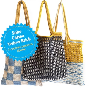 May include: Three crocheted tote bags hanging from hooks. The bags are made with different colored yarn and patterns. The bag on the left is blue and beige with a checkered pattern. The bag in the middle is black and white with a grid pattern. The bag on the right is yellow and blue with a wave pattern. A blue starburst sticker with the text "Soho Caissa Yellow Brick 3 crochet patterns ebook" is in the foreground.