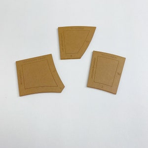 May include: Three brown paper templates for a double wedding ring. The templates are labeled A, B, and C. Each template has the text "Double Wedding Ring" and "EZERVEK.COM" printed on it. The templates are 18 inches in size.