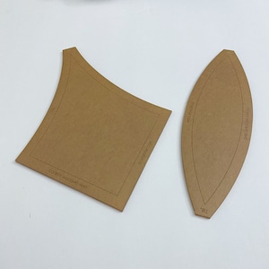 May include: Two brown cardboard templates for crafting. The larger template is a square with rounded corners and the text "DO IT YOURSELF" and "ENJOYEVERY.COM". The smaller template is an oval shape with the text "DO IT YOURSELF" and "ENJOYEVERY.COM".