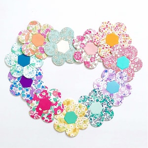 May include: A heart-shaped arrangement of 12 fabric flower appliques in various colors and patterns, including pink, blue, green, and white.