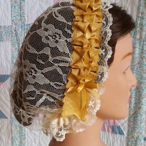 Goldfarbene Tageskappe aus Creme Spitzen mit Bändern