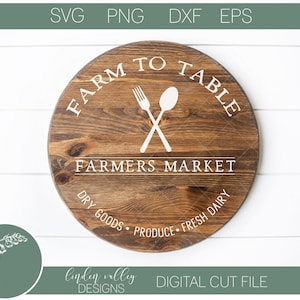 May include: A round wooden sign with the text "Farm to Table" and "Farmers Market" in white lettering. The sign also includes a fork and spoon crossed over each other, and the text "Dry Goods, Produce, Fresh Dairy".