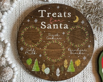 May include: A wooden round tray with the text "Treats for Santa" and three sections labeled "Fresh Cookies", "Cold Milk", and "Reindeer Snacks". The tray is decorated with green wreaths, red berries, and a small moon.