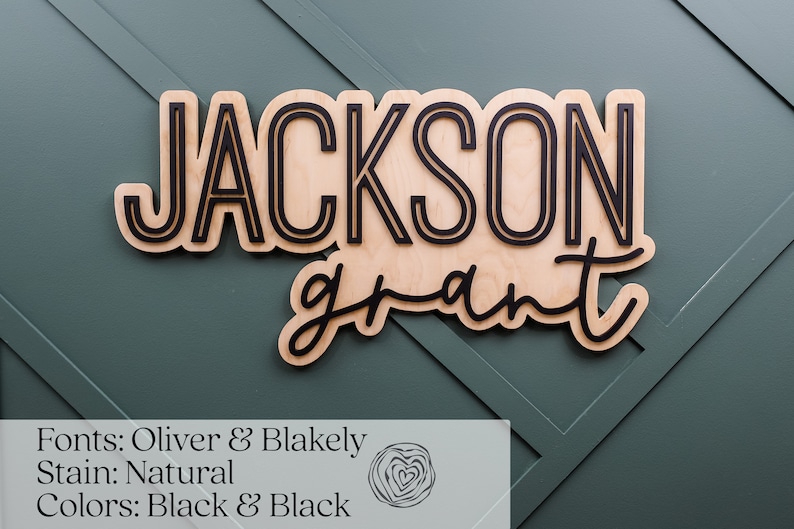May include: A custom wooden wall sign featuring the name JACKSON in a bold, sans-serif font and the name grant in a cursive script. The letters are black and mounted onto a natural light-coloured wood backing with a cutout shape.