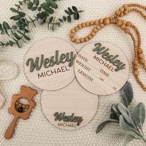 May include: Three wooden baby announcement plaques with the name "Wesley Michael" in green script. The middle plaque has spaces to fill in the baby's date, weight, time, length in pounds and ounces.