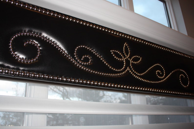 May include: A black window valance with a decorative silver bead trim and a silver beaded floral design.