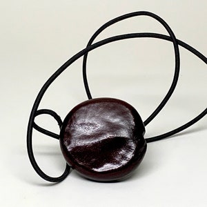 Sea Heart Hair Tie Lasso Is made from a bean that grows on trees in Europe. It can be worn as a necklace. Check it out image 5