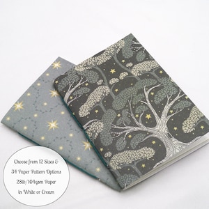 May include: Two notebooks with patterned covers. One features a dark gray background with a large tree and yellow stars. The other has a light gray background with yellow stars. Text reads: Choose from 12 Sizes & 34 Paper Pattern Options 28lb/104gsm Paper in White or Cream.