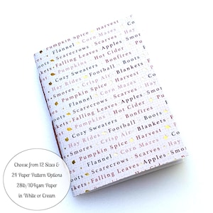 May include: A small, rectangular notebook with a fall-themed pattern. The cover features words like "Pumpkin Spice," "Bonfires," and "Apples" in a repeating pattern with gold accents. The notebook is available in 12 sizes and 24 paper pattern options.