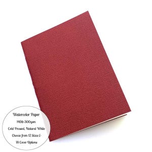 May include: A deep red watercolour paper pad with a textured cover. The image text reads: Watercolor Paper, 140lb 300gsm, Cold Pressed, Natural White, Choose from 12 Sizes & 18 Cover Options.