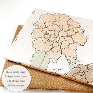 May include: Two pieces of paper with different patterns. The top piece of paper is white with a floral design in shades of brown and green. The bottom piece of paper is brown with a small white dot pattern. The text on the top piece of paper reads: "Choose from 12 Sizes & 24 Paper Pattern Options 28lb/104gsm Paper in White or Cream".