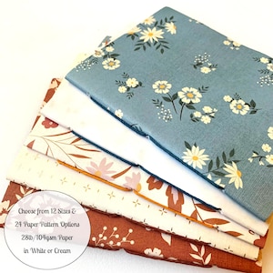 May include: A stack of five different patterned paper sheets in shades of blue, white, cream, and orange. The paper is 28lb/104gsm and available in white or cream. Choose from 12 sizes and 24 paper pattern options.
