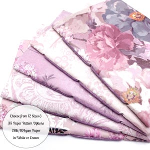May include: A stack of floral patterned paper in shades of pink, purple, and white. The paper has a variety of floral designs, including large peony blooms and smaller floral patterns. The text on the image reads: "Choose from 12 Sizes & 35 Paper Pattern Options 28lb/104gsm Paper in White or Cream."