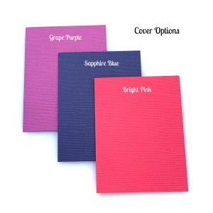 May include: Three notebook cover options: Grape Purple, Sapphire Blue, and Bright Pink. The covers are textured and have a subtle sheen.