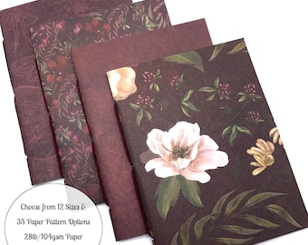 Puede incluir: Un conjunto de cuadernos con diseños florales en tonos burdeos y marrón. Un cuaderno presenta una gran flor blanca y rosa. El texto de la imagen dice: "Choose from 12 Sizes & 35 Paper Pattern Options 28lb/104gsm Paper in White or Cream."