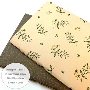 May include: Two notebooks, one with a cream-colored floral pattern and the other with a dark green leaf pattern. The cream notebook has a design of green leaves and yellow flowers. The text on the image reads: Choose from 12 Sizes & 24 Paper Pattern Options 28lb/104gsm Paper in White or Cream.