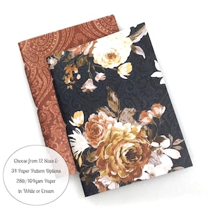 May include: Two rectangular paper sheets with floral and paisley patterns. One sheet features a dark background with cream and brown roses, while the other has a rust-colored paisley print. Text reads: Choose from 12 Sizes & 34 Paper Pattern Options 28lb/104gsm Paper in White or Cream.