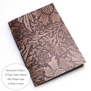 May include: A rectangular notebook featuring a dark brown cover with a repeating floral and leaf pattern in a lighter tan shade. A circular white graphic overlay includes the text: Choose from 12 Sizes & 34 Paper Pattern Options 28lb/104gsm Paper in White or Cream.