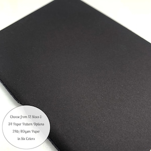May include: A close-up of a stack of black paper. The paper has a textured surface. A white circle in the lower left corner contains text that reads: "Choose from 12 Sizes & 34 Paper Pattern Options 24lb/89gsm Paper in Six Colors."