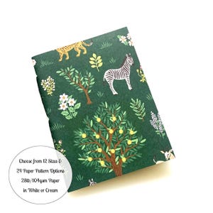 May include: A green notebook with a jungle animal print featuring zebras, leopards, and citrus trees. The notebook is made with 28lb/104gsm paper and is available in white or cream. Choose from 12 sizes and 24 paper pattern options.