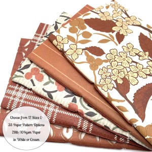 May include: A stack of patterned paper sheets in various designs and colors, including floral, plaid, and striped patterns. The color palette features shades of brown, cream, and white. Text on the image reads: "Choose from 12 Sizes & 35 Paper Pattern Options 28lb/104gsm Paper in White or Cream."