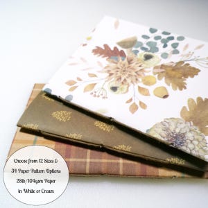 May include: Three stacked sheets of paper with distinct designs. The top sheet features a floral and botanical print in muted earth tones. The middle sheet is dark brown with a gold pinecone pattern. The bottom sheet has a brown plaid pattern.