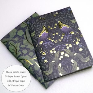 May include: Two notebooks featuring a dark purple and green botanical pattern with gold foil accents depicting birds and flowers. A circular text overlay states: Choose from 12 Sizes & 34 Paper Pattern Options, 28lb/104gsm Paper in White or Cream.