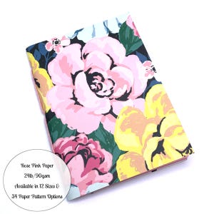 May include: A floral notebook with a vibrant design. The cover features large pink and yellow flowers against a dark background. The text on the image says "Rose Pink Paper 24lb/90gsm Available in 12 Sizes & 34 Paper Pattern Options."