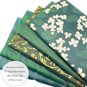 May include: A selection of notebooks featuring green floral and leaf designs, bound with green thread. The image includes text stating "Choose from 12 Sizes & 35 Paper Pattern Options 28lb/104gsm Paper in White or Cream."