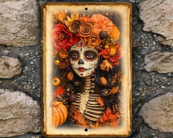 May include: Rectangular metal sign featuring a Day of the Dead woman with elaborate floral headpiece and face paint. The artwork includes a skeleton torso, pumpkins, and autumn leaves, with a distressed, vintage-style border.