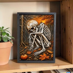 May include: A framed artwork depicts a skeleton in a forest setting. The skeleton is seated, with its head resting on its knees. The background features trees, autumn leaves, and a small pumpkin. The color palette includes shades of brown, orange, and beige.