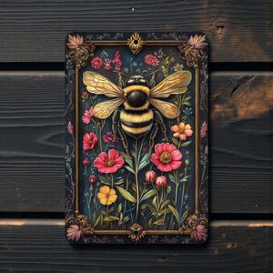 Pu&ograve; includere: Opera d'arte da parete rettangolare con un'illustrazione dettagliata di un'ape con le ali spiegate, su uno sfondo di fiori colorati. L'ape &egrave; nera e gialla, circondata da fiori rosa, rossi e gialli. L'opera &egrave; incorniciata con un bordo dorato.