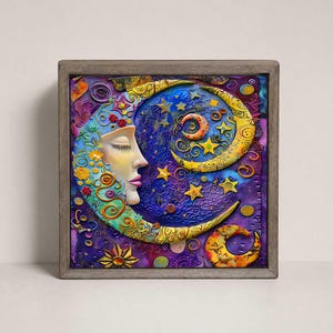 May include: A square framed wall art piece featuring a textured, colorful crescent moon with a human face profile. The artwork displays vibrant shades of blue, purple, yellow, and orange, decorated with small floral motifs, stars, and swirls.