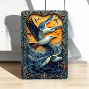 May include: Rectangular art piece featuring three seagulls in flight over a stylized ocean. The birds have white bodies, gray wings, and orange feet. The background is a blend of orange and blue, with a decorative border.