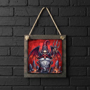 May include: Square framed art print featuring a gnome with a long white beard, wearing a red hat with a skull, and holding a trident. The artwork has a red background with dark accents and is suspended by a rope.