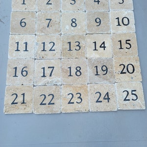 May include: Twenty-five square tiles with a beige background and black numbers from 1 to 25.