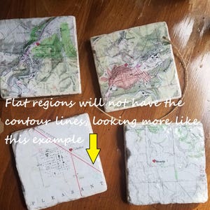 K&ouml;nnte beinhalten: Vier quadratische Untersetzer aus Keramik mit gedruckten Vintage-Karten. Die Karten zeigen H&ouml;henlinien und die Namen von St&auml;dten, darunter Deadwood, Lead, Colome und Wewela.