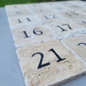 May include: A set of beige stone tiles with black numbers from 1 to 21. The tiles are arranged in rows and columns, with the number 21 in the bottom right corner.