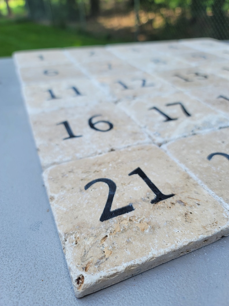 May include: A set of beige stone tiles with black numbers from 1 to 21. The tiles are arranged in rows and columns, with the number 21 in the bottom right corner.