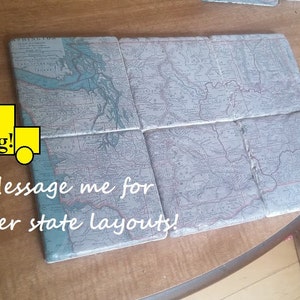 Puede incluir: Conjunto de seis posavasos de cerámica con mapas vintage de los Estados Unidos. Los posavasos están dispuestos en una cuadrícula, con cada posavasos representando una región diferente del país. Los posavasos son de color azul claro con líneas marrones y negras que representan las fronteras de los estados y los ríos. El texto "FREE Shipping!" y "**Message me for other state layouts!" es visible en la imagen.