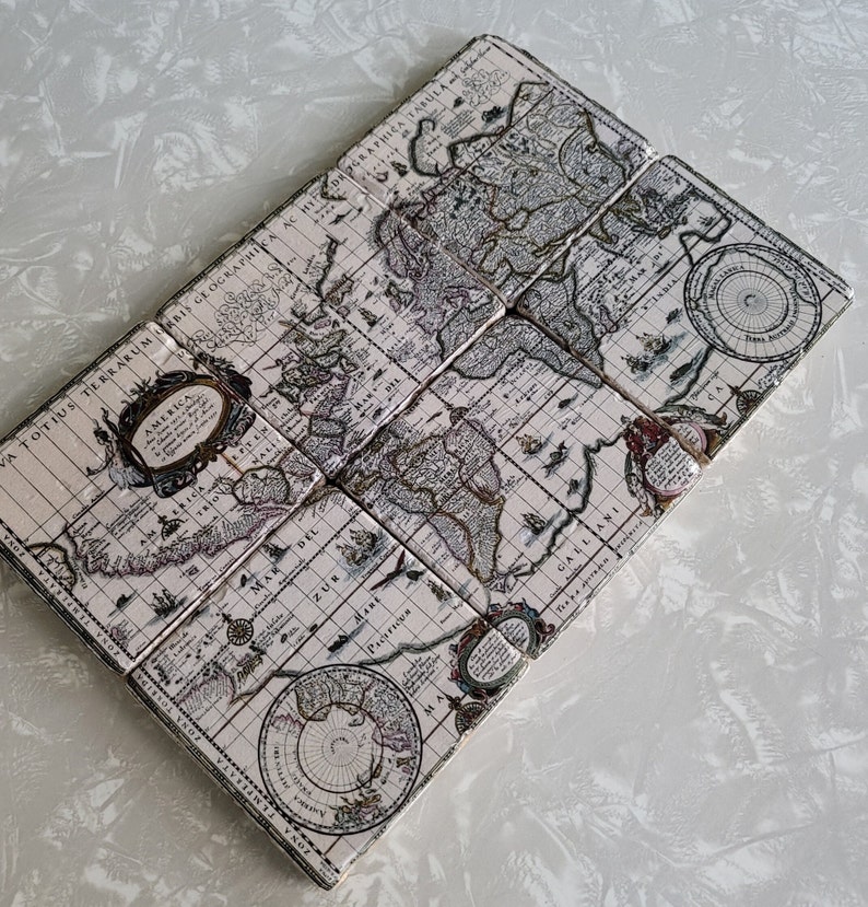 Puede incluir: Un conjunto de seis posavasos cuadrados dispuestos en forma de diamante. Cada posavasos presenta un dise&ntilde;o de mapa antiguo detallado en beige, marr&oacute;n y negro. El mapa incluye texto e ilustraciones intrincadas.