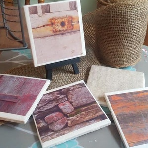 May include: Six square ceramic coasters with different designs. The coasters feature images of a rusty metal door, a brick wall, a wooden door, a stone wall, and two abstract designs.