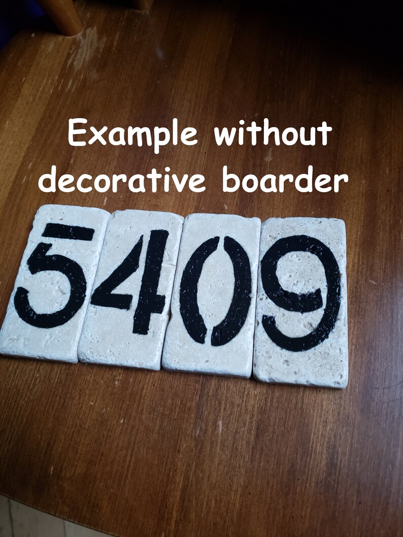 May include: Close-up of four white ceramic tiles with black painted numbers, reading "5409". The tiles are arranged in a row on a wooden surface.