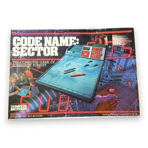 May include: A rectangular board game box for Code Name: Sector, the computer game of submarine pursuit by Parker Brothers. The cover features a blue grid game console, illustrations of people playing, and red neon-style text and graphics.
