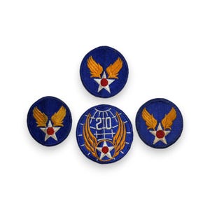 May include: Four embroidered patches with a military theme. The patches are primarily blue with gold wings, a white star, and a red center. One patch features the number "20" within a globe design.