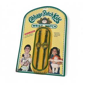 May include: A Cabbage Patch Kids wrist watch set in original packaging. The yellow card features two dark green watches with round faces, text reading "SPECIAL BONUS! A PLAY WATCH FOR YOUR KID!", "Precision Movement", and "Adjustable Bands".