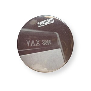 May include: A circular pinback button featuring a sepia-toned photograph of a VAX 8800 computer system. The word digital is printed in a white rectangular box at the top. The design includes a metallic finish and a smooth, rounded edge.